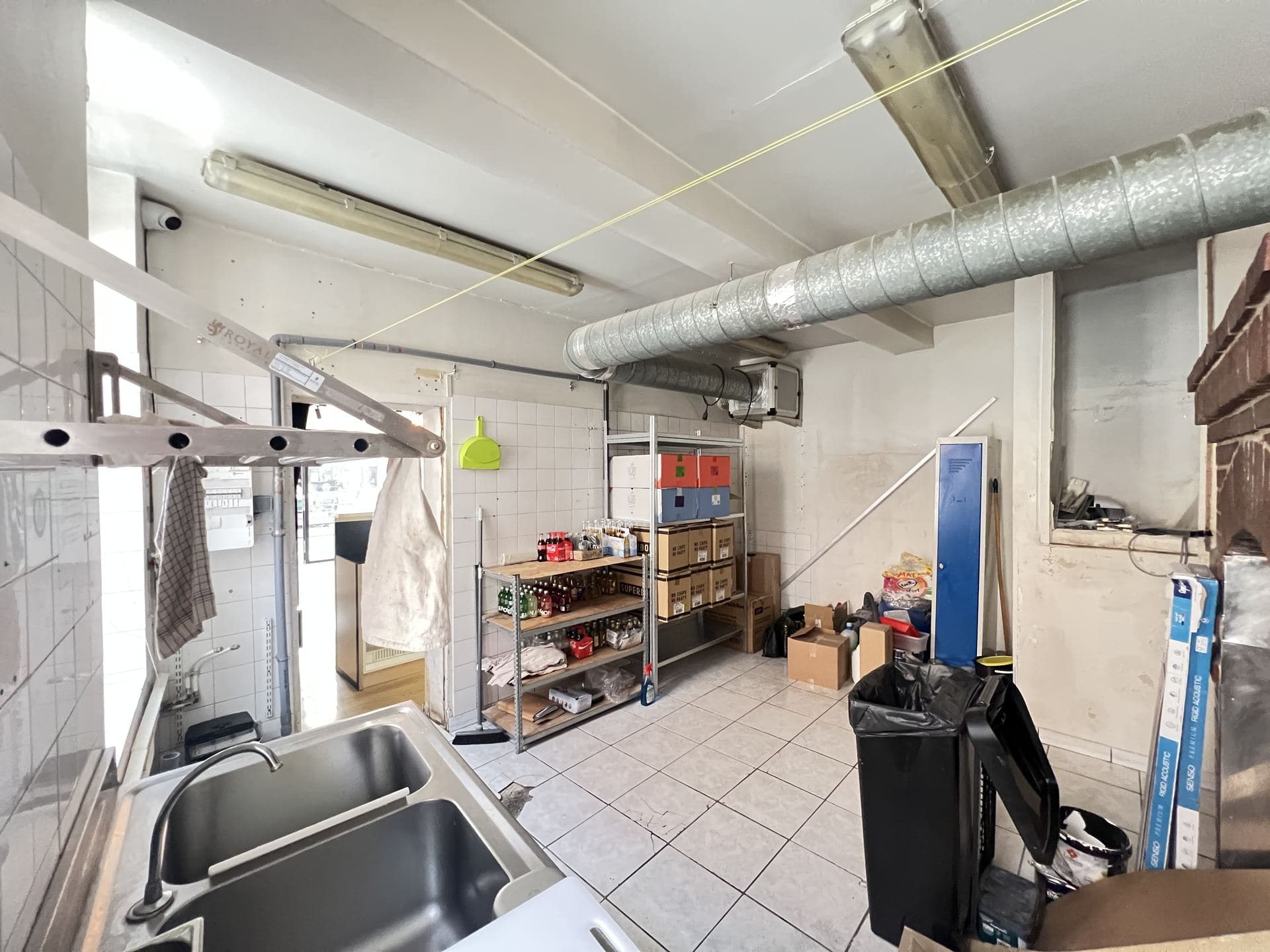 Arrière-boutique avec plonge et espace de stockage