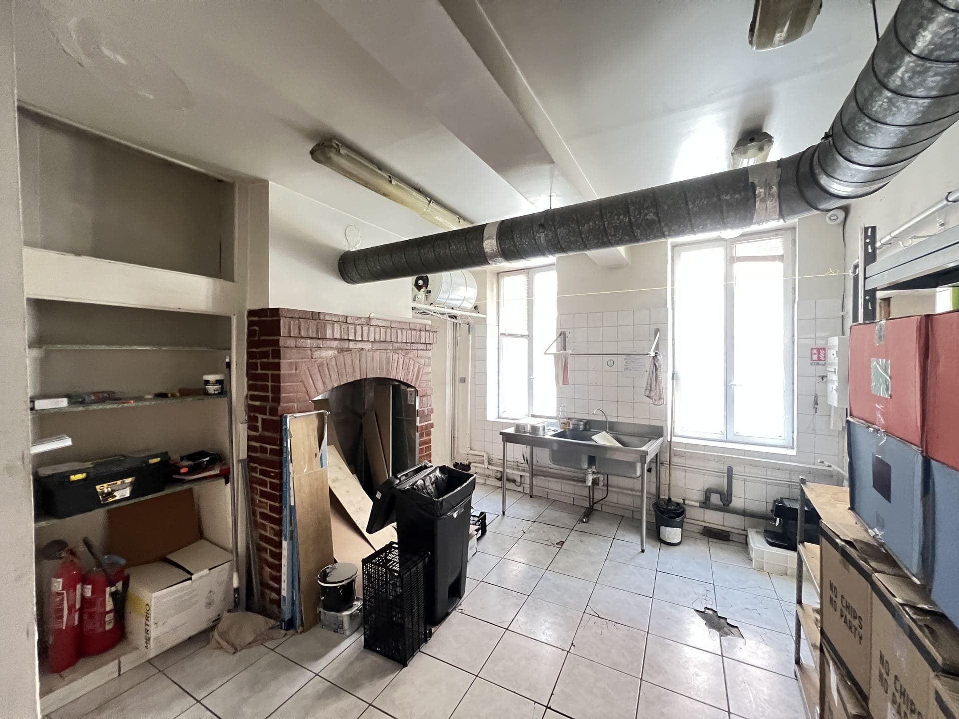 Arrière-salle avec cheminée en briques d'origine